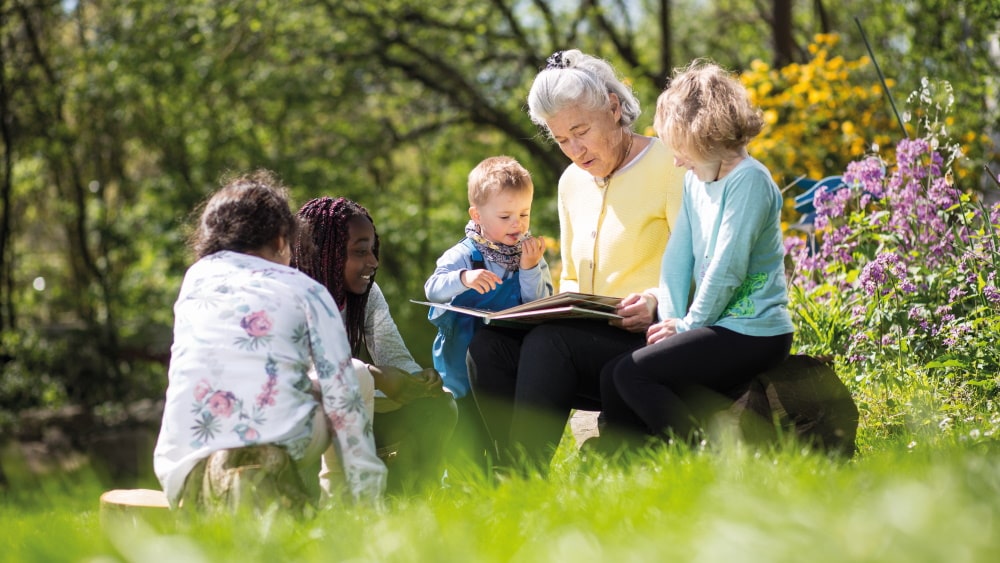 mujer mayor leyendo a niños de un libro