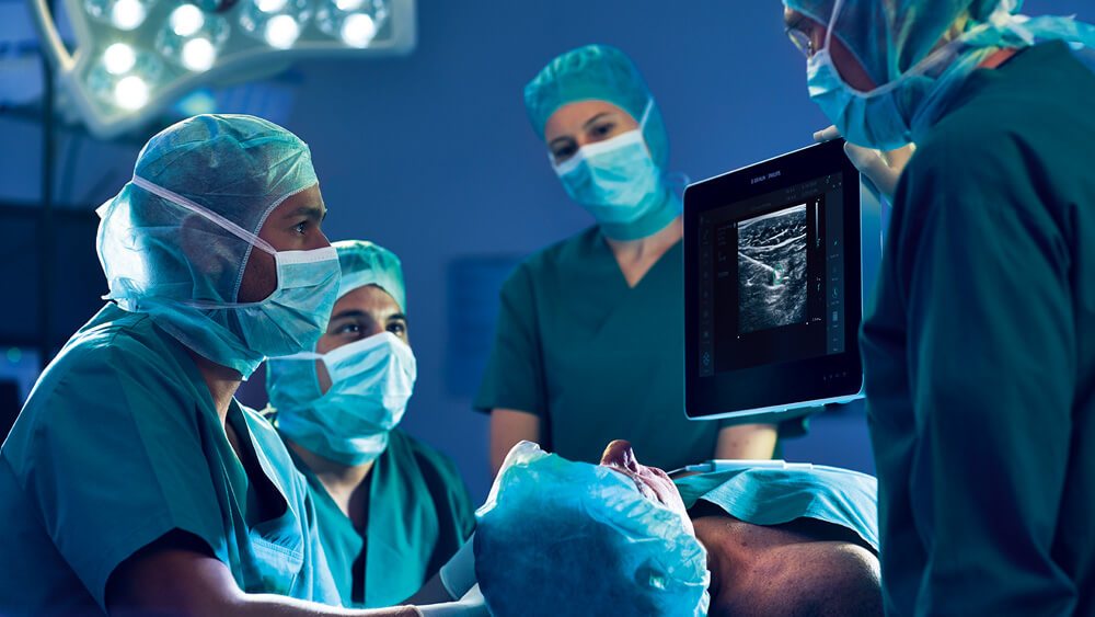 El personal médico observa un bloqueo del plexo infraclavicular guiado por ecografía en un monitor en el quirófano