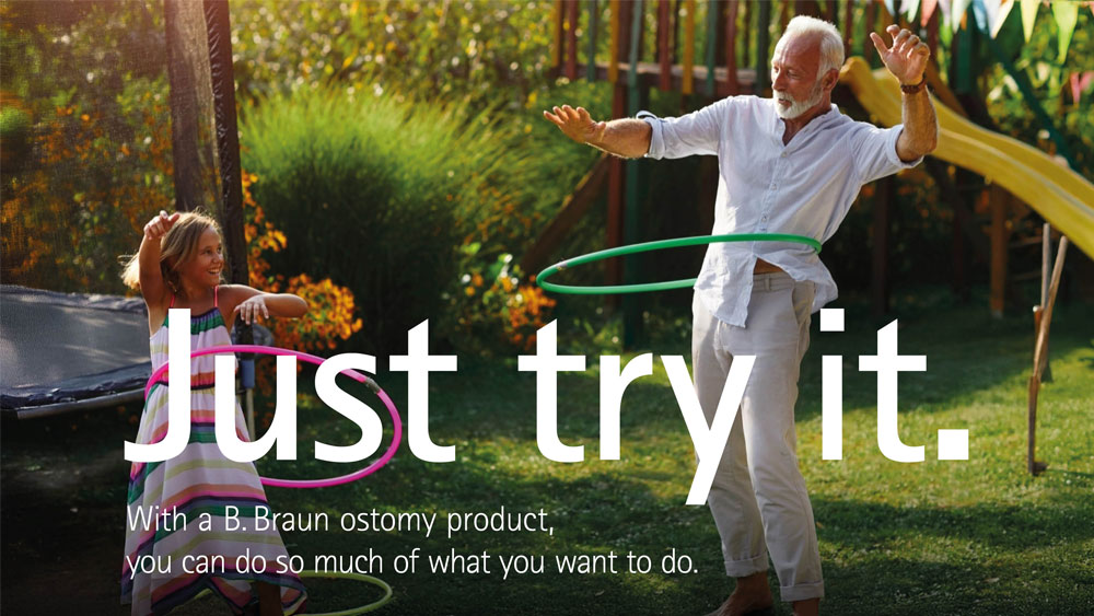 A grandparent and a child hula hooping together in a sunny backyard with green grass, colorful flowers, and a yellow slide in the background. The text on the image reads Just try it. With a B. Braun ostomy product, you can do so much of what you want to.