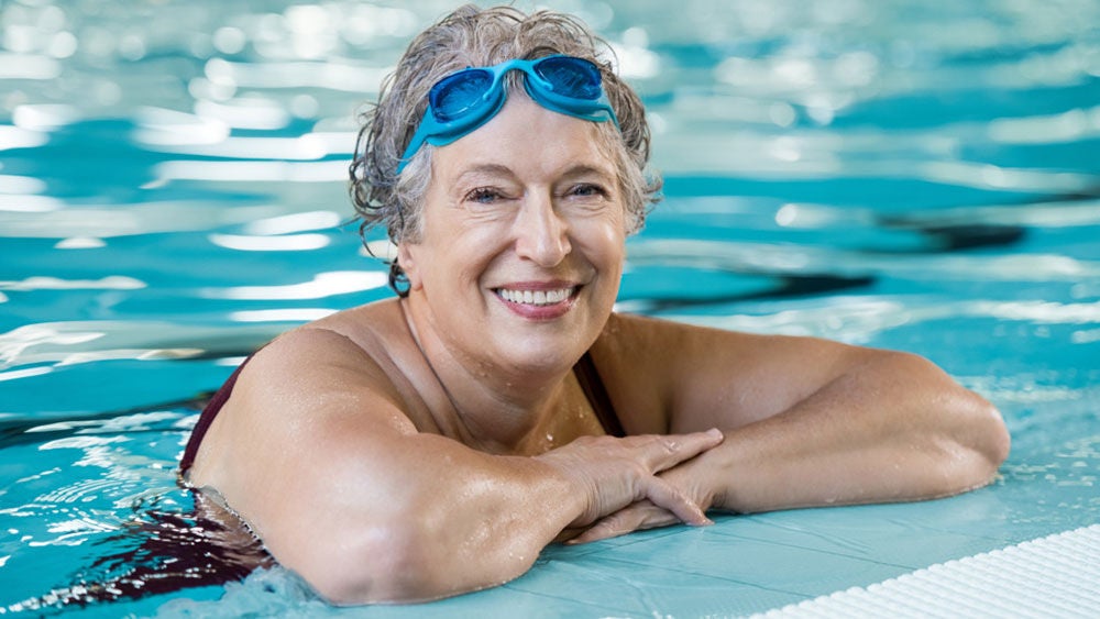 mujer en una piscina con gafas de sol en la frente