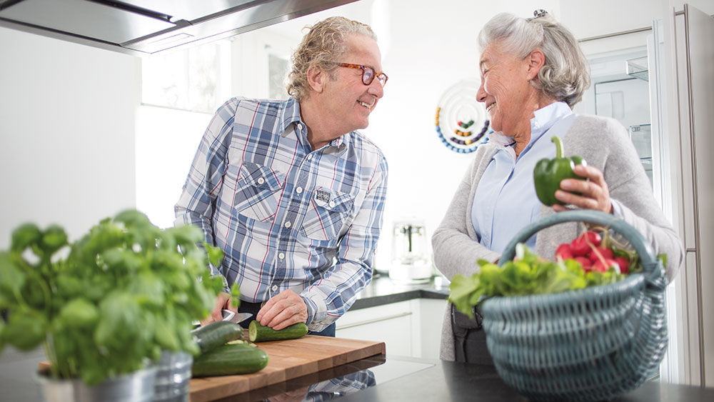 hombre y mujer preparan verduras juntos