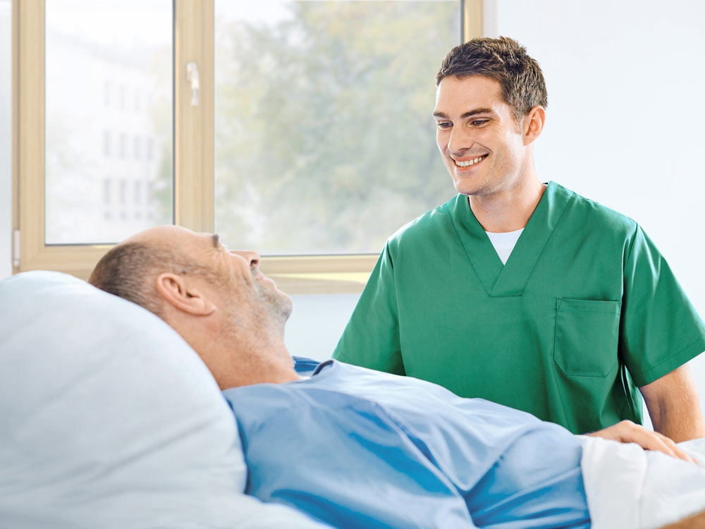 enfermera y paciente hablando junto a la cama