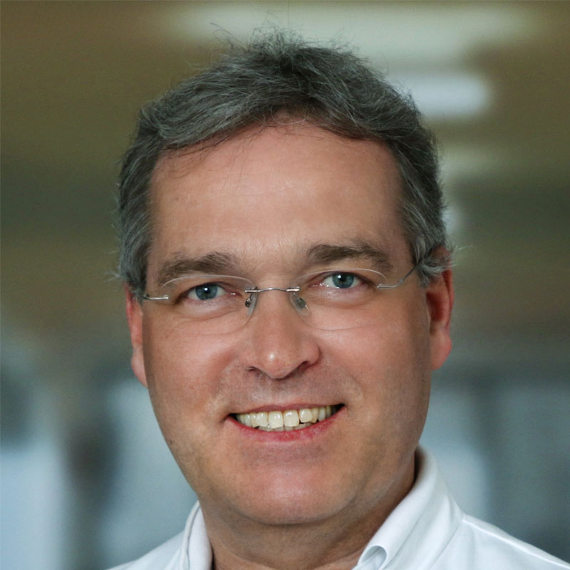 Retrato del profesor Markus Golling con el abrigo de un médico sonriendo con confianza a la cámara